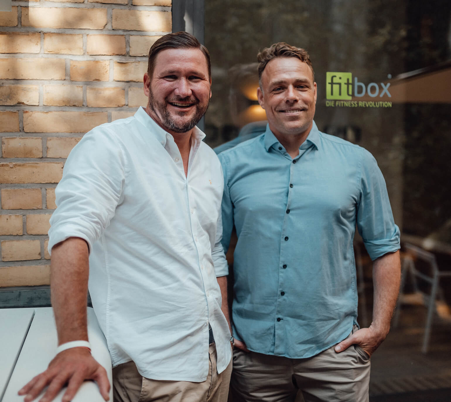 The fitbox founders stand in front of the studio - success story and partnership in the EMS franchise system.
