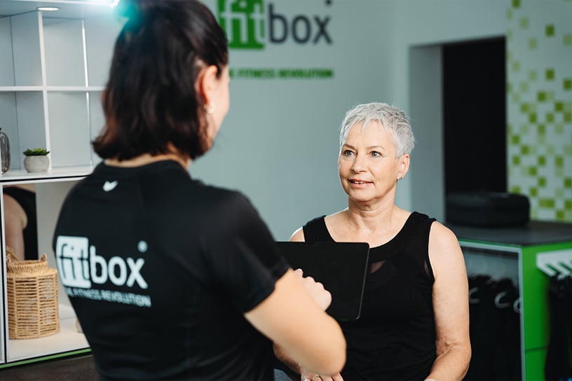 fitbox Trainerin führt Beratungsgespräch mit Kundin zur Zieldefinition – individuelles EMS-Training nach persönlichen Bedürfnissen.