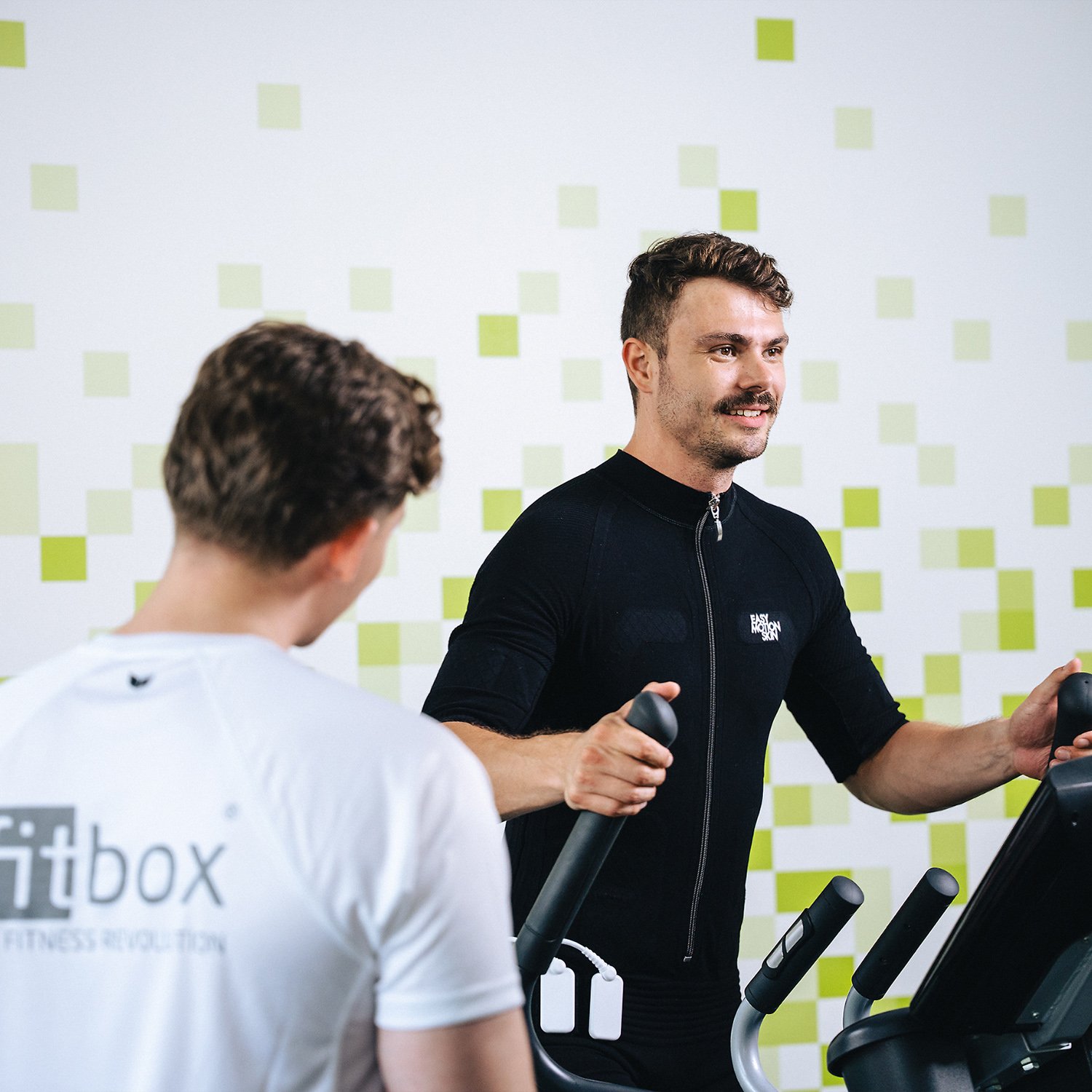 fitbox Kunde trainiert im EMS-Anzug auf dem Crosstrainer – aktives Training zur Stärkung des Immunsystems.