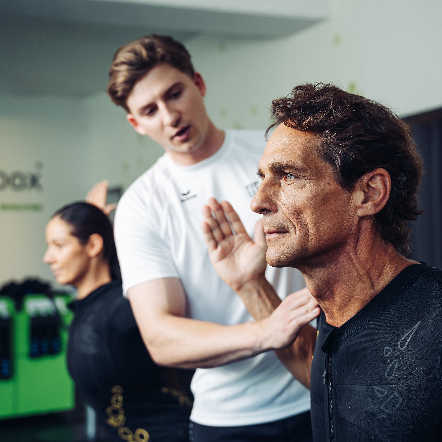 fitbox Trainer unterstützt Kunden bei Rückenübung im EMS-Training – für starke Muskulatur und bessere Haltung.